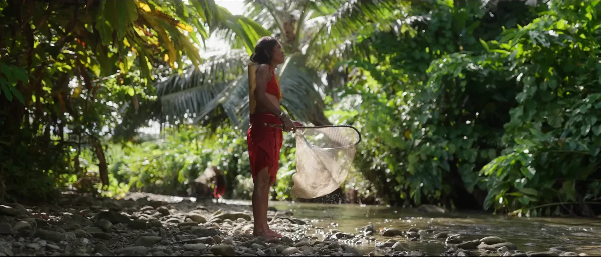 Femme mentawai pêchant à l'épuisette dans une rivière de la jungle de Siberut île Mentawai traditions ancestrales