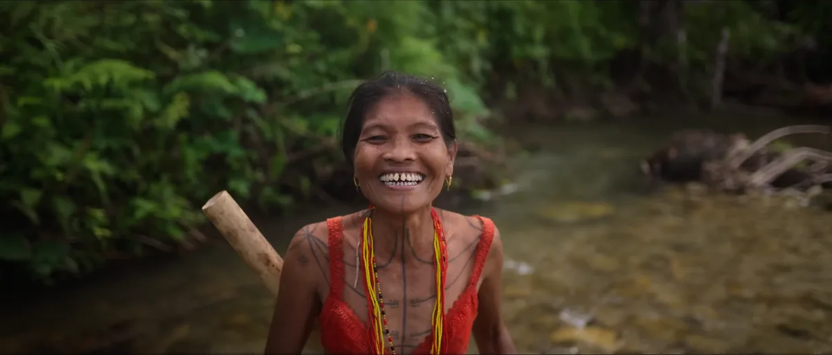 Homme mentawai tatoué marchant dans la jungle tropicale de l'île de Siberut en Indonésie en pagne traditionnel