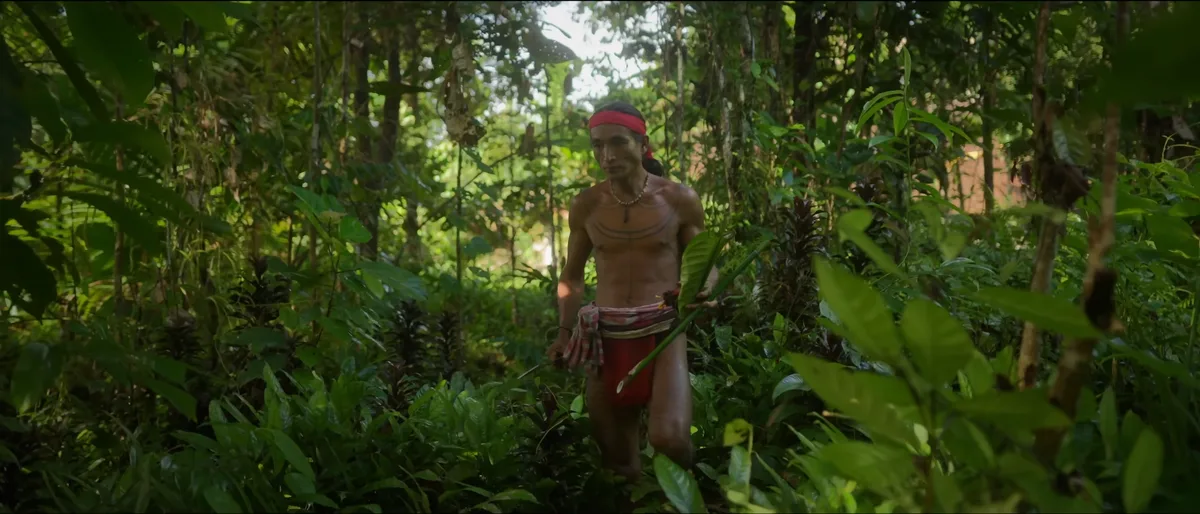 Chamane sikerei mentawai âgé avec tatouages traditionnels et colliers de perles à l'intérieur d'une uma sur l'île de Siberut