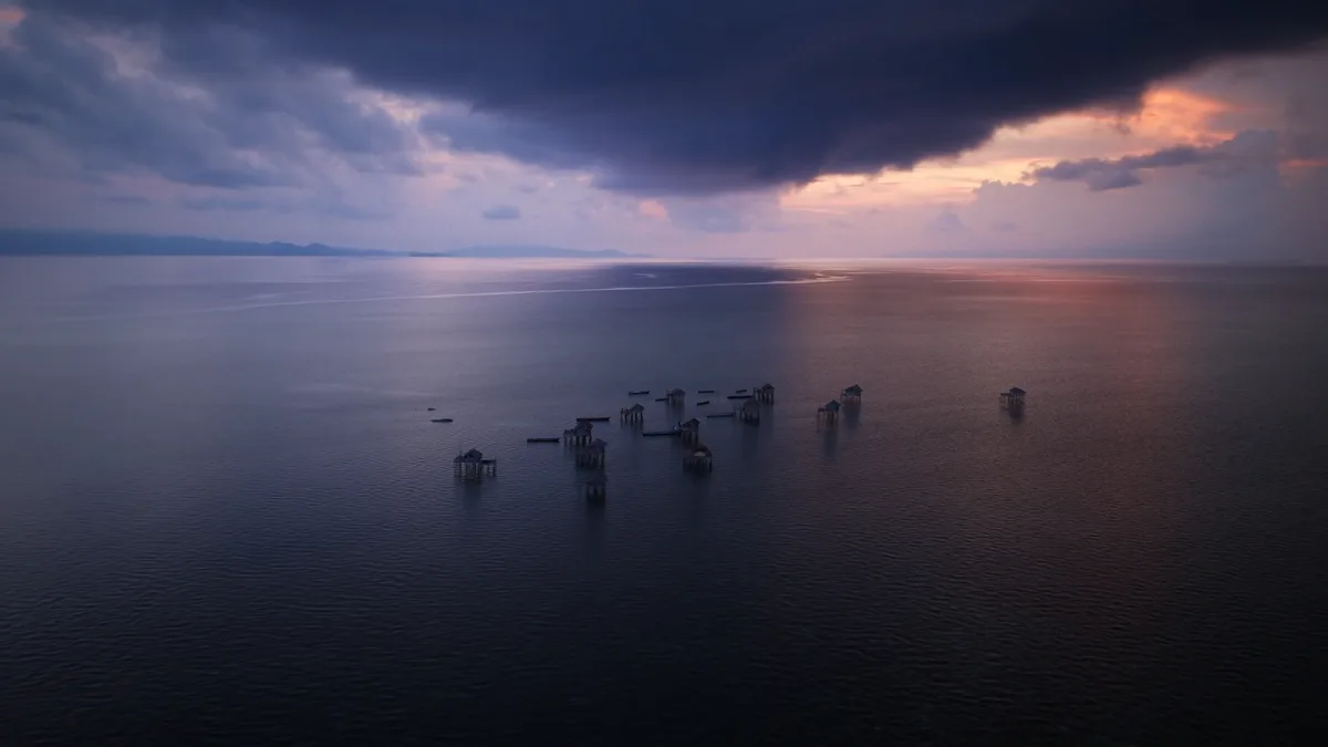 Plongeur bajau fouillant les herbiers marins en apnée avec lunettes en bois traditionnelles Indonésie