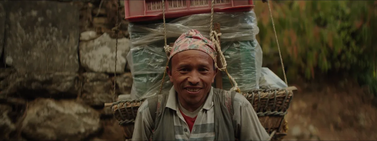 Porteur sherpa transportant 60 kg de matériel en altitude dans la vallée du Khumbu au Népal