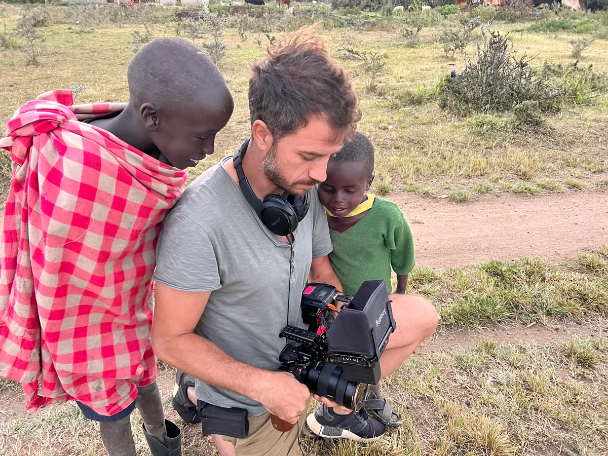 Vidéaste montrant ses images à des enfants Massai en Tanzanie tournage documentaire solo connexion humaine terrain