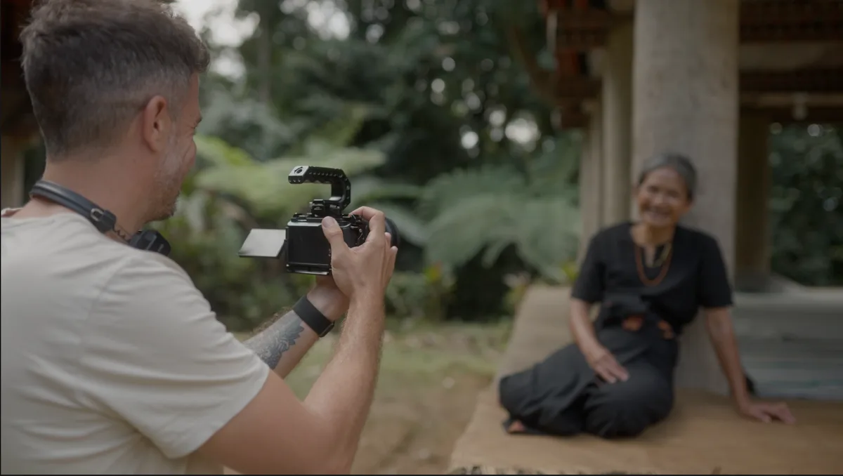 Vidéaste filmant un portrait en documentaire de voyage avec un rendu cinématique bokeh en lumière naturelle